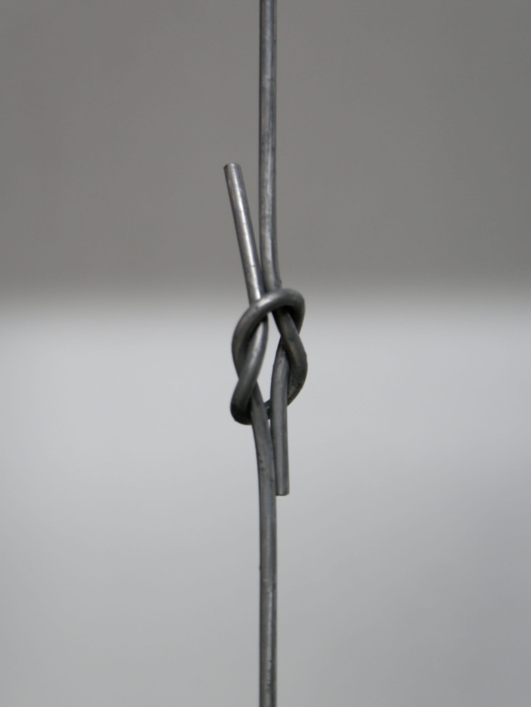 Baling wire tied and pulled on the test bench, showing knot strength