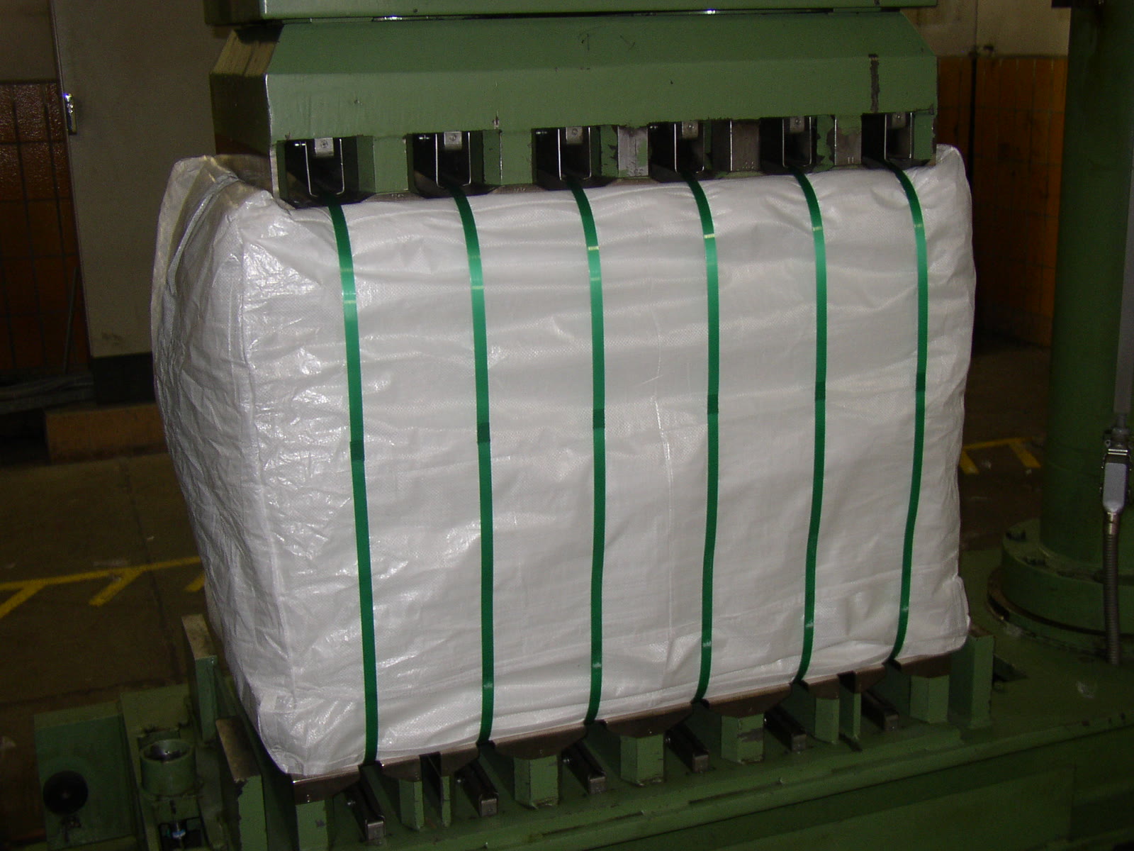 White woven bale cover strapped over a finished bale