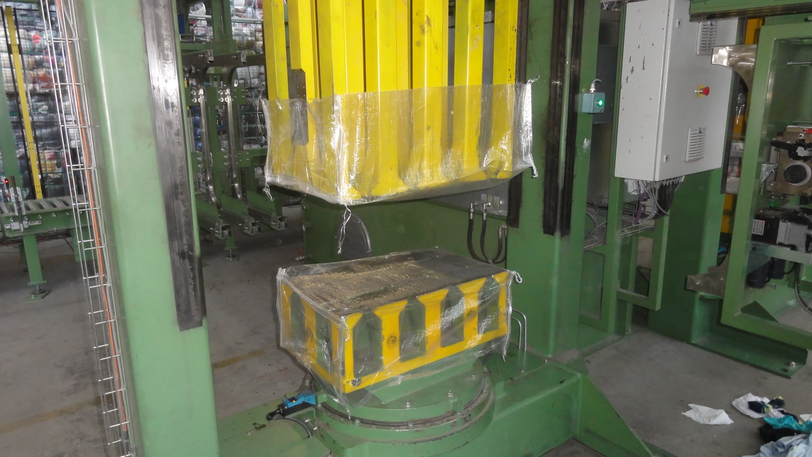 A wrapped bale being formed and covered under the baling press