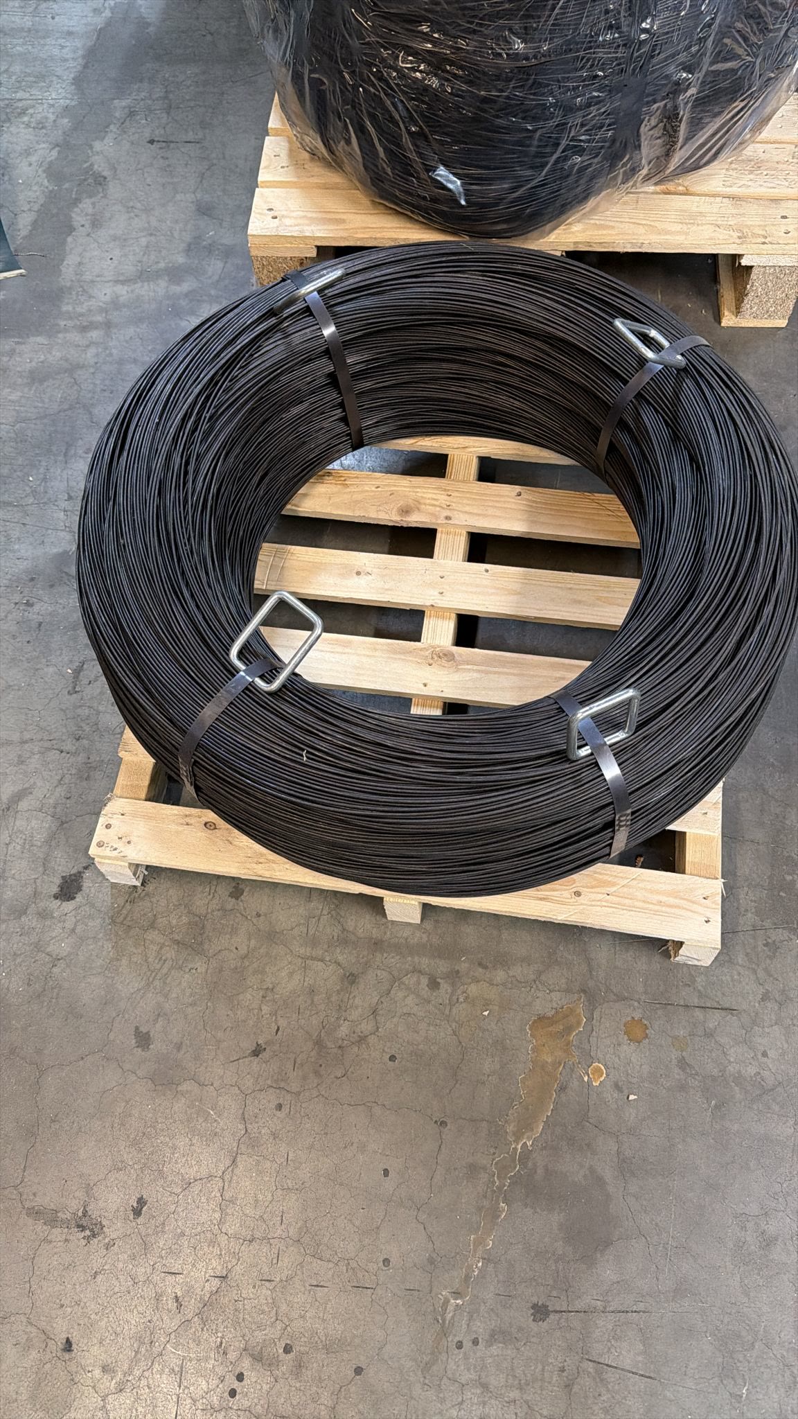 A black annealed baling wire rosette coil on a pallet