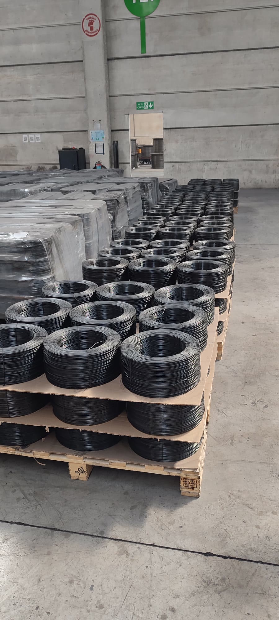 Black annealed wire rosettes stacked by the pallet in the warehouse