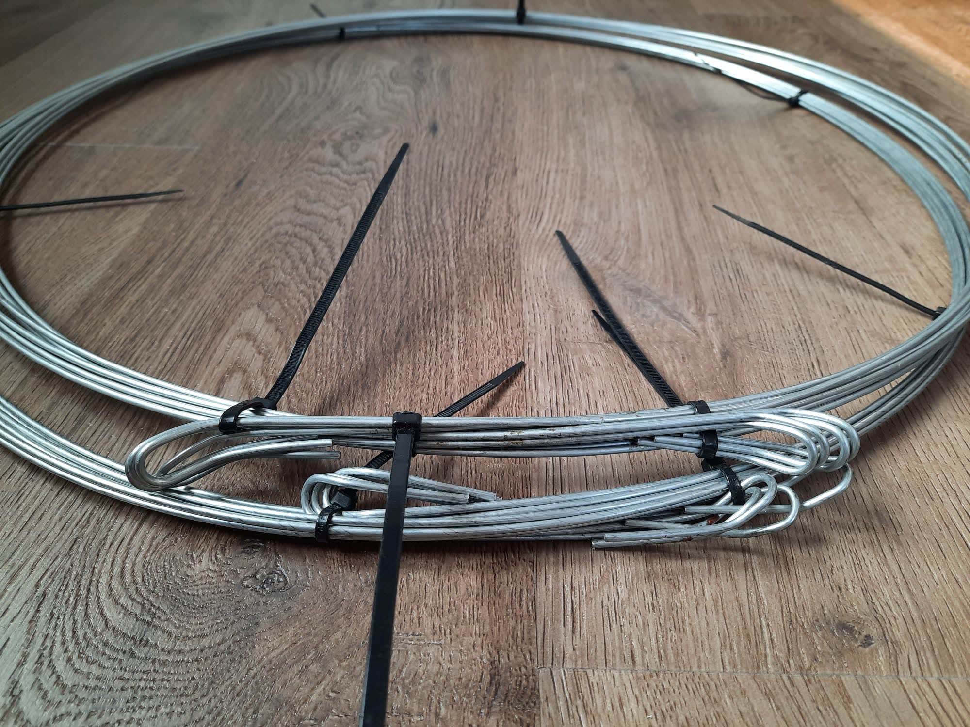 Large roll of galvanized quick link bale ties coiled and held with cable ties